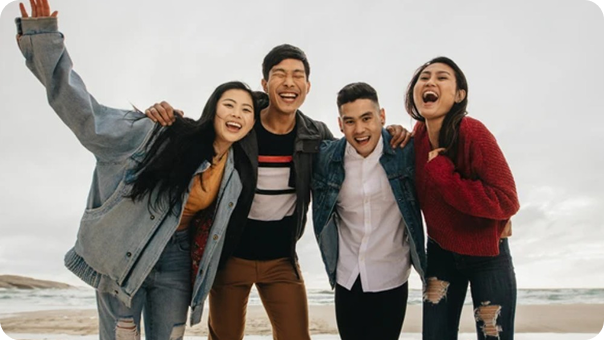 4 person laughing while holding on to each other